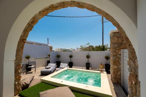 an archway over a swimming pool on a patio at Kasteli Suites in Perivolos