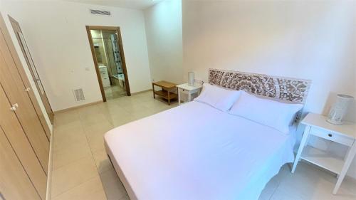 sypialnia z białym łóżkiem i lustrem w obiekcie BEACH VALENCIA 13 - Luxury Beachfront Apartament w Walencji