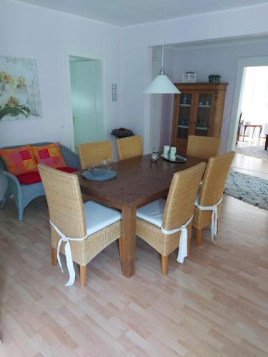 a dining room table with wicker chairs in a living room at Ferienwohnung in Bad Eilsen in Bad Eilsen