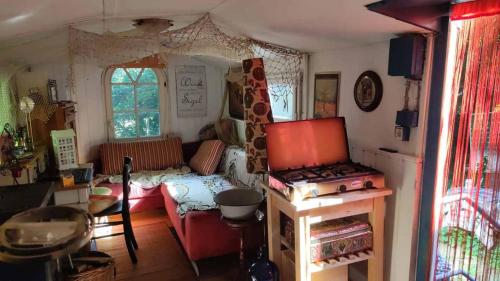 a room with a living room with a stove in it at Trailer - DSCHUNGEL LODGE in Küps