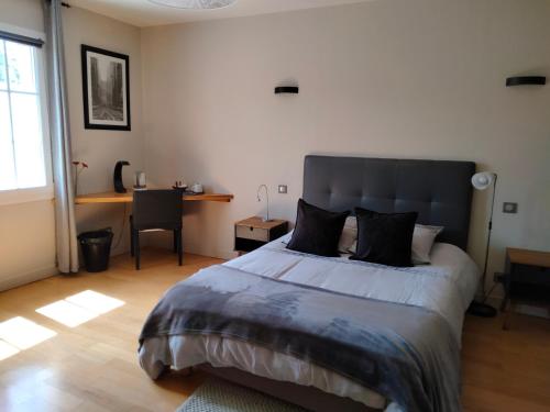 a bedroom with a large bed and a desk at Au Saint-Amand in Poissons