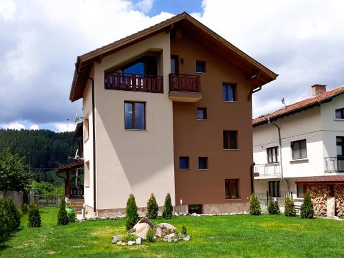 a large house with a green yard in front of it at ВИЛА Belle Vie in Beli Iskar