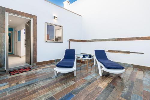 - une salle d'attente avec des chaises bleues et un miroir dans l'établissement Dimore Italiane - Boutique Apartments, à Corralejo