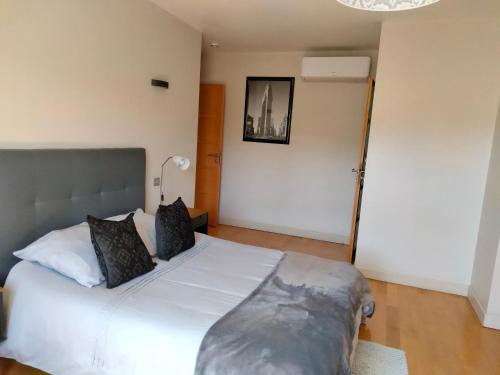a bedroom with a bed with white sheets and black pillows at Au Saint-Amand in Poissons