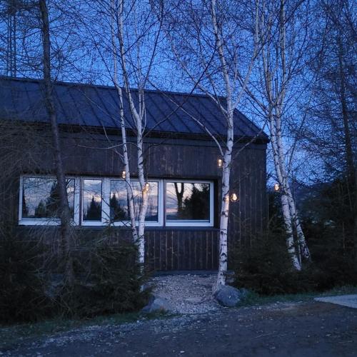 a house with lights in the windows of it at Domki na Widoku in Lubomierz