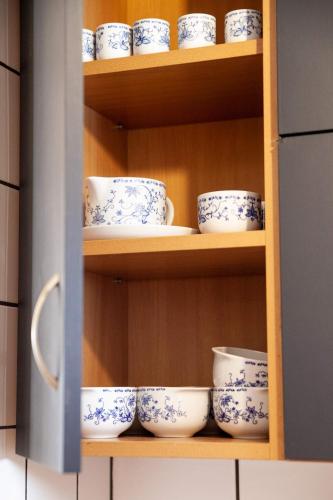 a shelf filled with blue and white cups and saucers at Domki na Widoku in Lubomierz