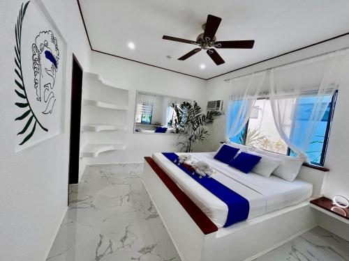 1 dormitorio con 1 cama y ventilador de techo en Pawikan Boutique Hotel en Moalboal