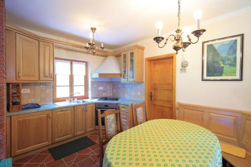 a kitchen with wooden cabinets and a table in it at Zadnjica Holiday House in Soča