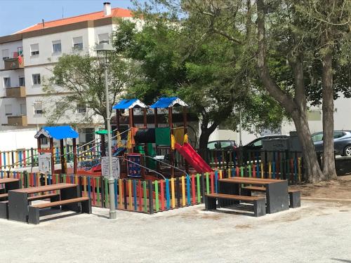 a playground in a park with benches in front at Casa dos Capinha in Caldas da Rainha