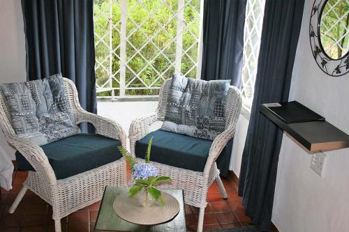 two wicker chairs and a table in front of a window at Sabie Star in Sabie