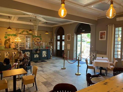 a restaurant with tables and people sitting at tables at Le Grand Hôtel Molière in Pézenas