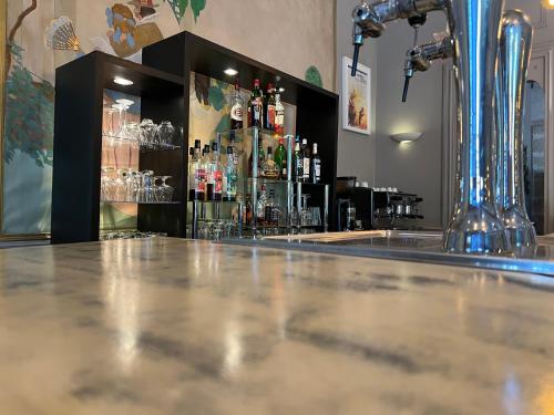 a bar with a counter with bottles of alcohol at Le Grand Hôtel Molière in Pézenas