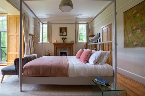 a bedroom with a canopy bed and a fireplace at Home Farm Oban in Oban