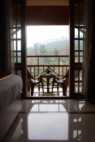 a room with a table and chairs on a balcony at Tea county in Munnar