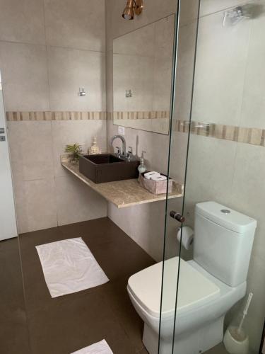 a bathroom with a toilet and a sink at Apartamento na Montanha em Campos in Campos do Jordão