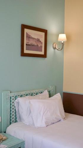 a bed with white sheets and a picture on the wall at Radisson Blu Resort El Quseir in Quseir
