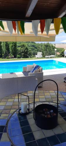 a patio with a pool and a table with a fire pit at Villa Lara in Marsaglia