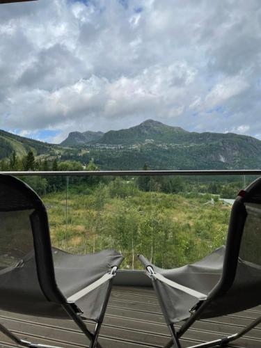 two chairs on a porch with a view of mountains at Snøya Lodge in Hemsedal