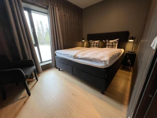 a bedroom with a bed with a large window at Snøya Lodge in Hemsedal