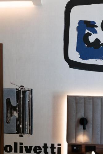 a wall with a mirror and a sign on it at 3T Boutique Hotel in Ivrea