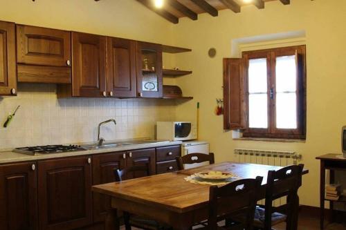 a kitchen with a wooden table with chairs and a sink at Podere I Laghi in Tavarnelle in Val di Pesa