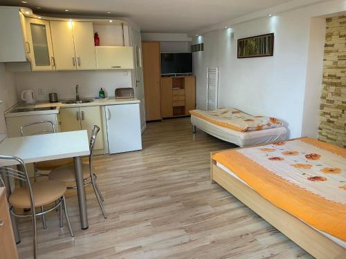 une petite chambre avec deux lits et une cuisine dans l'établissement Willa Sara, à Ustka