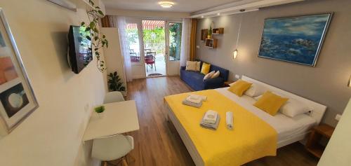 a bedroom with a yellow bed and a yellow table at Apartments & Rooms KARLA in Dramalj