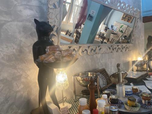 a cat statue sitting on a table in front of a mirror at El Chili Boutique Hotel in Barbate