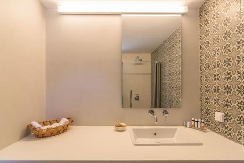 a bathroom with a sink and a mirror at Gazia Guesthouse Milos in Adamas