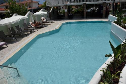a large blue swimming pool with chairs and umbrellas at Magic Tulip Hotel in Oludeniz