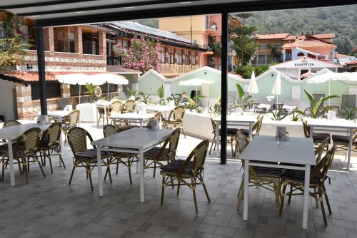 an outdoor patio with tables and chairs and tablesearcher at Magic Tulip Hotel in Oludeniz