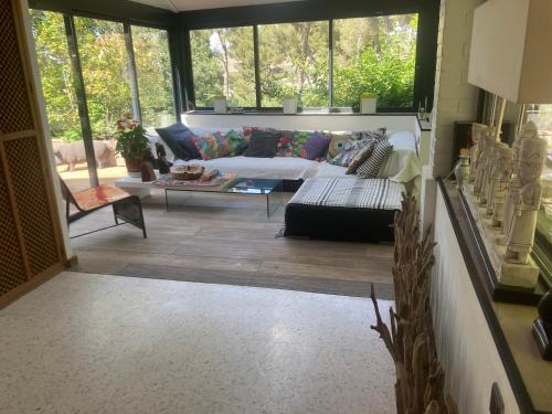a living room with a couch and a table at Villa de charme avec piscine et jacuzzi dans cadre exceptionnel proche Marseille in Les-Pennes-Mirabeau