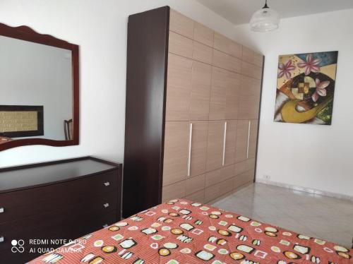a bedroom with a bed and a dresser and a mirror at Sardinia ovest in Oristano