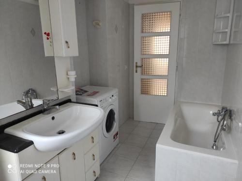 a white bathroom with a sink and a washing machine at Sardinia ovest in Oristano