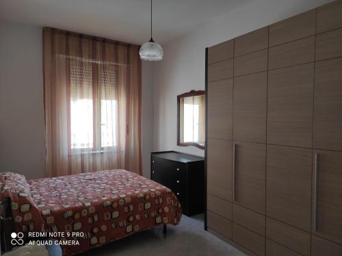 a bedroom with a bed and a dresser and window at Sardinia ovest in Oristano