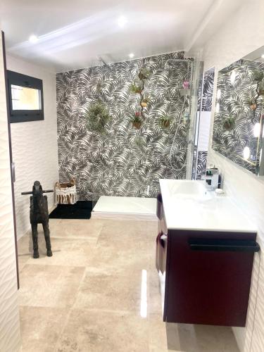 La salle de bains est pourvue d'un mur noir et blanc à motifs. dans l'établissement Maison de charme avec piscine et jacuzzi dans cadre exceptionnel proche Marseille, aux Pennes-Mirabeau