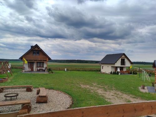 a farm with a house and a playground and a building at Domek u Lipków na Kaszubach "Iga" JACUZZI in Lipusz