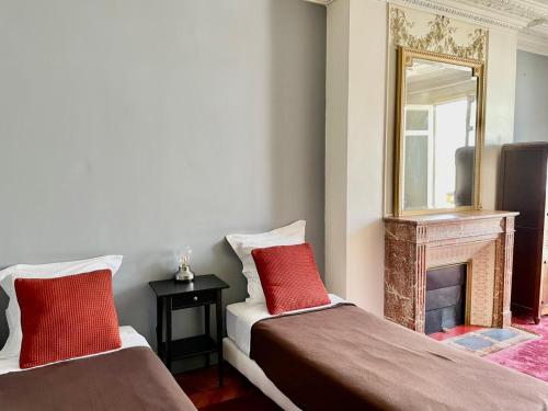 - 2 lits dans une chambre avec un miroir et une cheminée dans l'établissement Haussmann Opera Penthouses 130M2, à Paris
