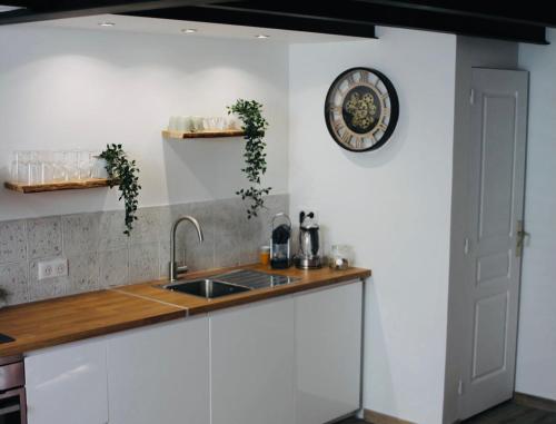 une cuisine avec un évier et une horloge murale dans l'établissement Duplex atypique rénové en plein centre du village, à Cassis