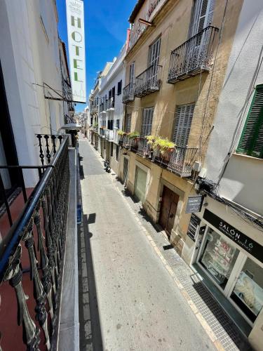 an empty street in a city with buildings at Madison Rooms in Sitges