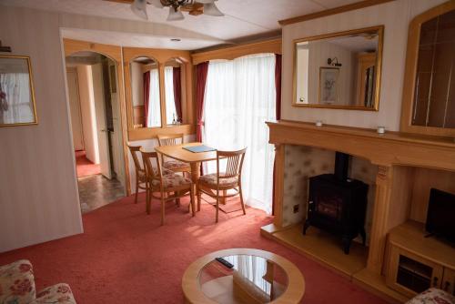 a living room with a table and a fireplace at Domek na Skraju Lasu II in Kruklanki