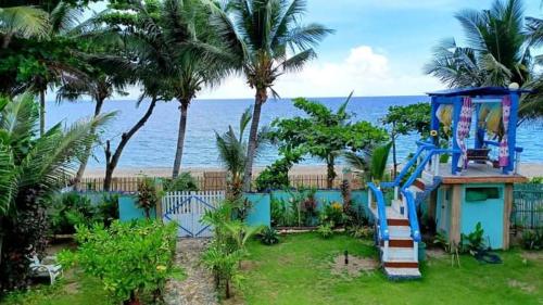 a house with a playground next to the ocean at Toni Arts Villa in Nabas