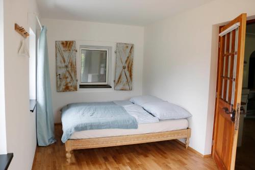 a bed in a room with a mirror and a window at Ferienwohnungen Tinymoon in Feldbach