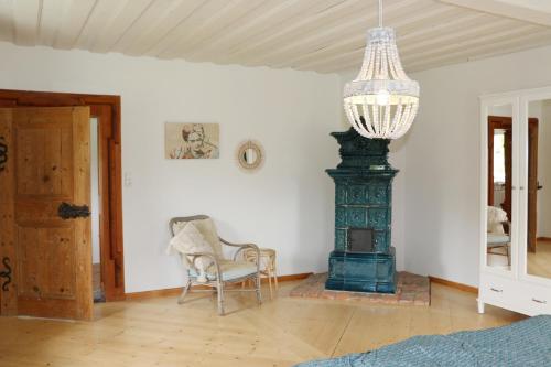 a room with a fireplace and a chair and a chandelier at Ferienwohnungen Tinymoon in Feldbach