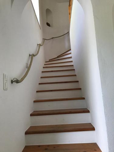 a staircase in a house with white walls and wooden floors at Ferienwohnungen Tinymoon in Feldbach