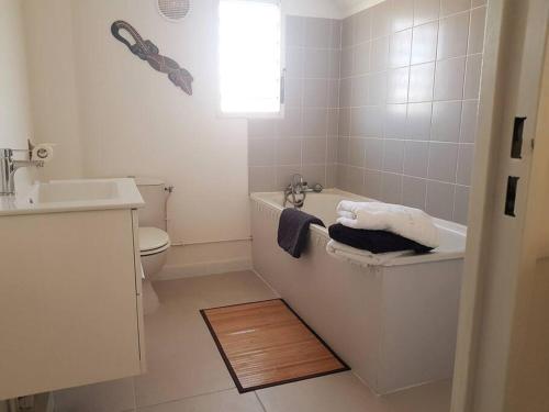La salle de bains est pourvue d'une baignoire, de toilettes et d'un lavabo. dans l'établissement Superbe studio avec varangue à 150 m de la plage à la saline les bains, à La Saline les Bains