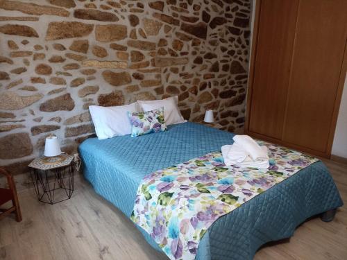 a bedroom with a bed and a stone wall at Refúgio do Côa - Pure Countryside Experience in Pinhel