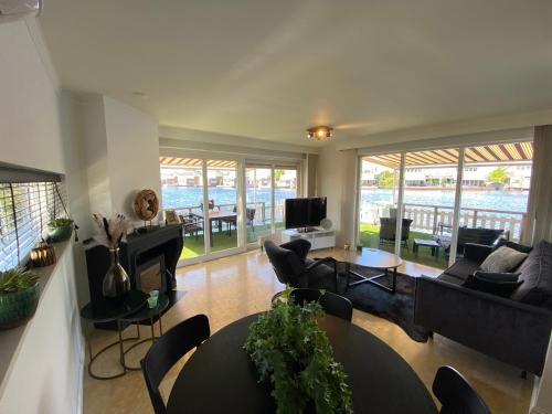 a living room with a couch and a table and chairs at Water Villa Minaro Vinkeveen in Vinkeveen