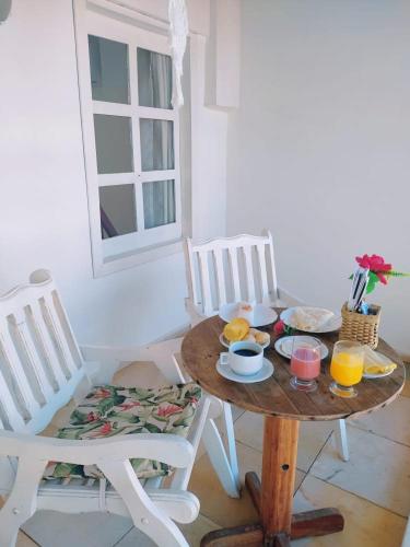 a table and chairs with a plate of food on it at Casarão Jeri in Jericoacoara