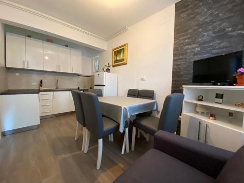een keuken en eetkamer met een tafel en stoelen bij Guest House Ruža in Sobra
